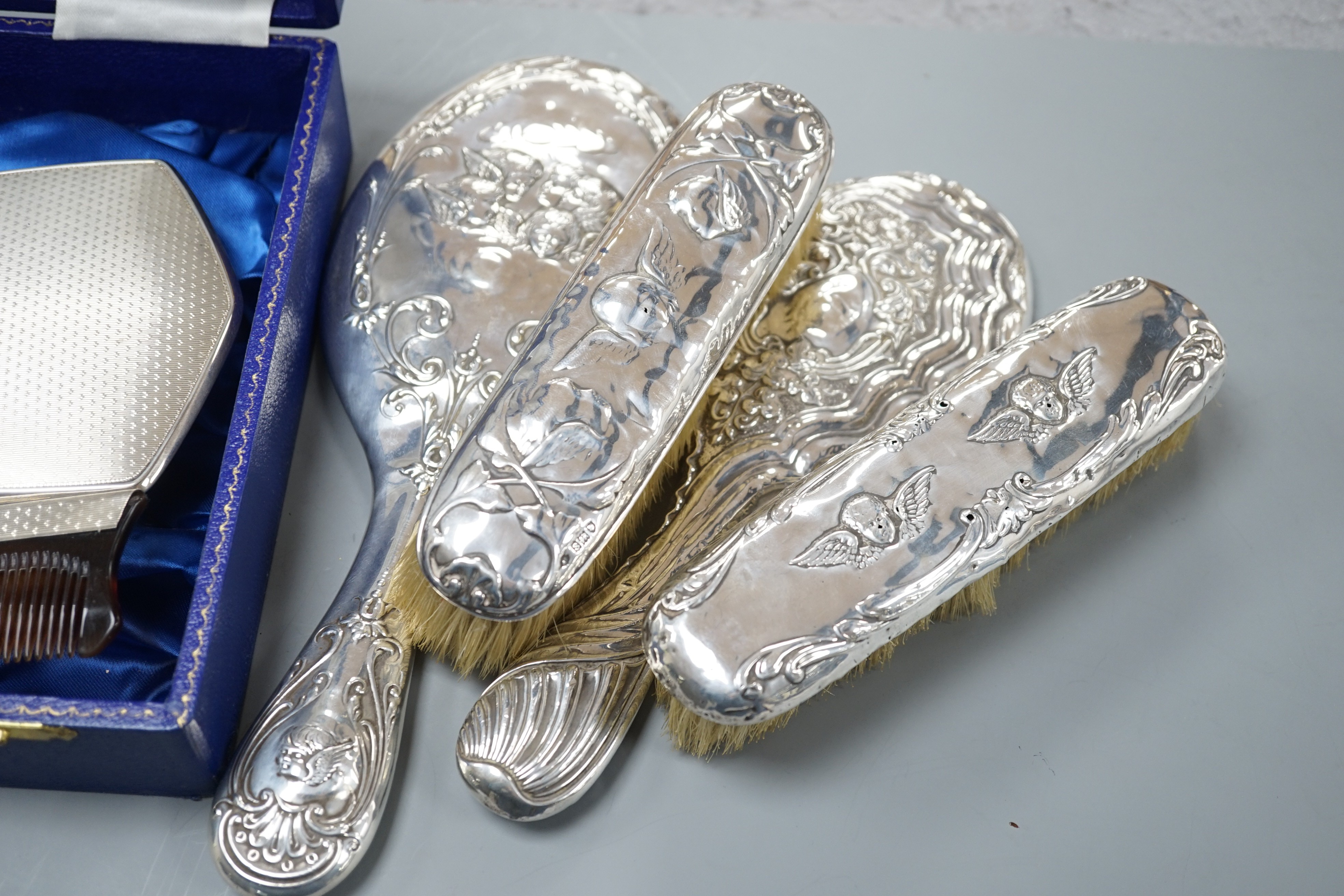 A cae 1970's engine turned silver mounted four piece mirror and brush set, two silver mounted hand mirrors and two silver mounted brushes.